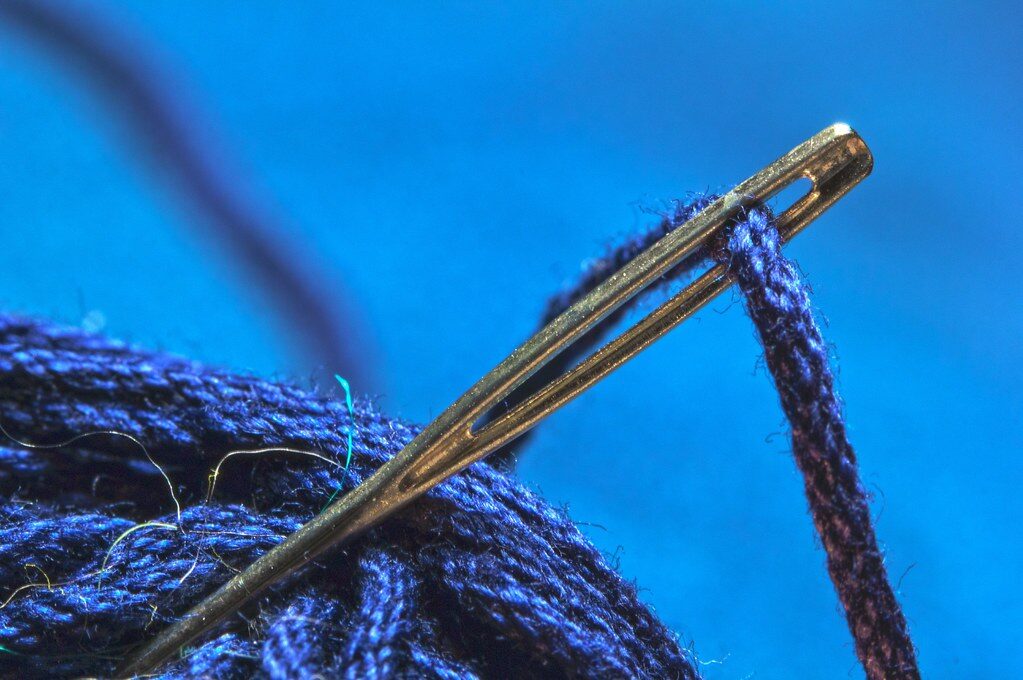 Nähnadel mit blauem Faden in Nahaufnahme